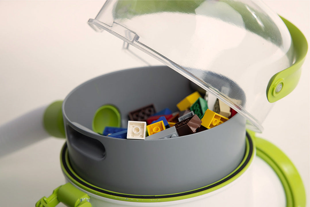 L'aspirateur Lego Pick-Up Bricks est un appareil portable et facile à utiliser qui aspire les Lego et autres petits jouets. La poignée colorée permet de soulever le couvercle transparent bombé, donnant ainsi accès aux Legos aspirés dans le panier gris situé au-dessus d'un second filtre collecteur de poussière et de saleté.