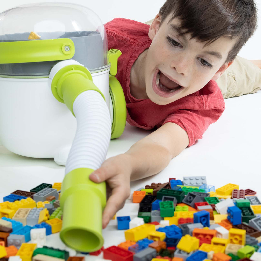 Tyler sucking up LEGO with his Pick-Up Bricks toy vacuum